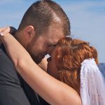 A man and woman kissing each other on the forehead.