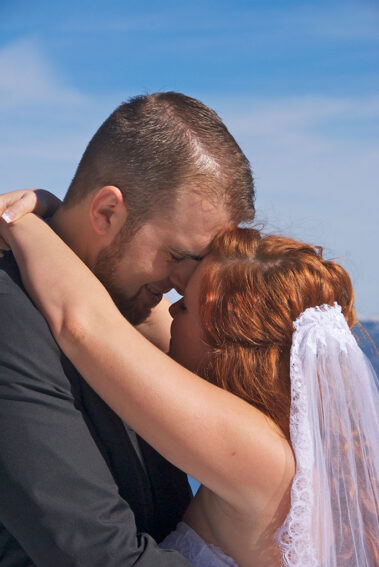 A man and woman kissing each other on the forehead.
