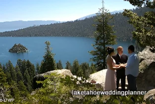 A couple getting married outdoors by a lake with an officiant, with a small island visible in the background.