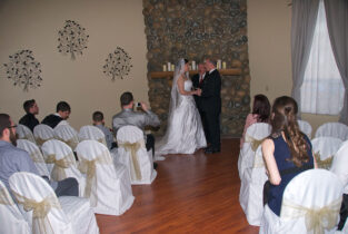 A couple getting married in front of the wedding party.