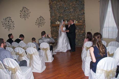 A couple getting married in front of the wedding party.