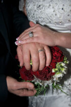 A close up of two hands with wedding rings on