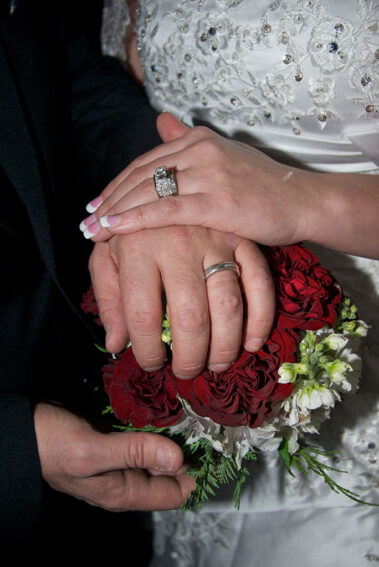 A close up of two hands with wedding rings on