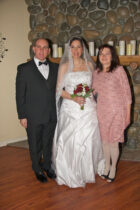 A bride and her parents posing for the camera.