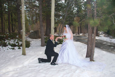 A man kneeling down to propose to his bride.