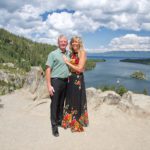 A man and woman posing for a picture on top of a mountain.