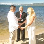 A couple getting married by the water