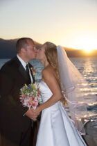 A bride and groom kissing on the beach
