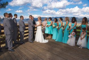 A group of people standing on top of a wooden deck.