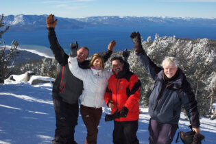 A group of people standing on top of a snow covered slope.