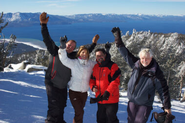 A group of people standing on top of a snow covered slope.