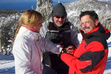 A group of people standing on top of a snow covered slope.