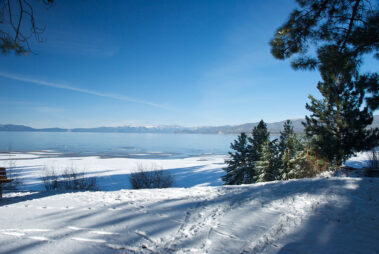 A view of the ocean from a snowy hill.