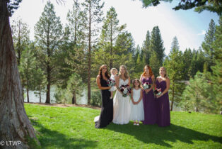 Bride with bridesmaids in varying shades of purple dresses