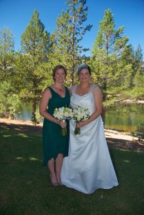 Two women in green dresses standing next to each other.