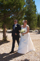A man and woman walking in front of trees.