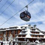 A ski lift with people on it and snow covered trees.