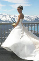 A bride in her wedding dress standing on the balcony of a hotel.