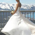 A bride in her wedding dress standing on the balcony of a hotel.