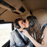 A man and woman kissing in the backseat of a car.