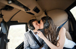 A man and woman kissing in the backseat of a car.