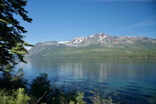 A lake with mountains in the background and trees