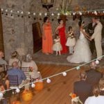 A wedding ceremony with people sitting in chairs.