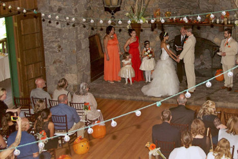 A wedding ceremony with people sitting in chairs.