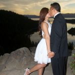 A man and woman kissing on the beach.